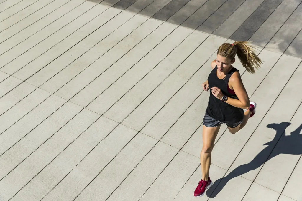 Donna vestita sportiva che corre su una strada